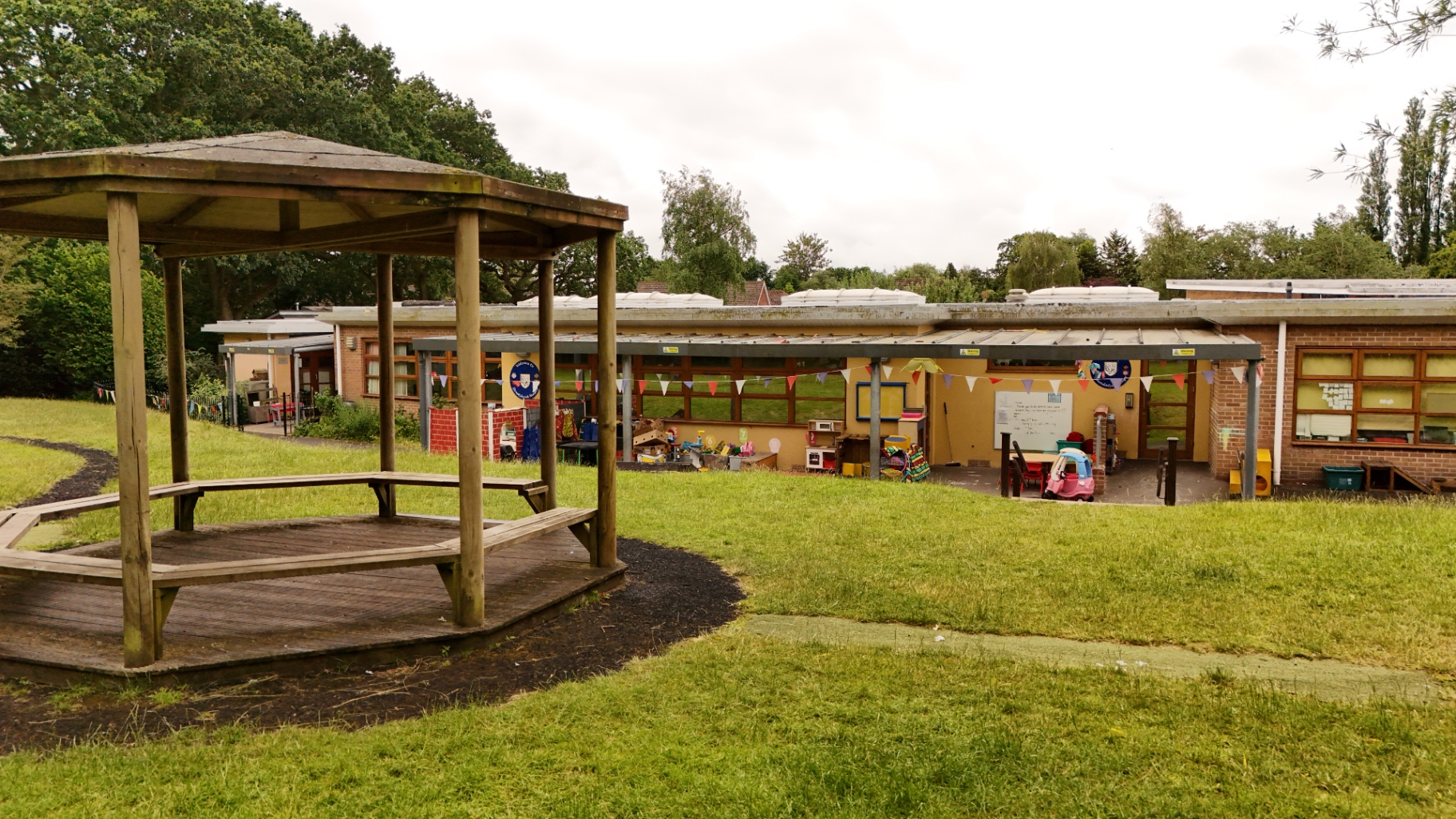 Ground-level view of a wooden gazebo and the nursery exterior