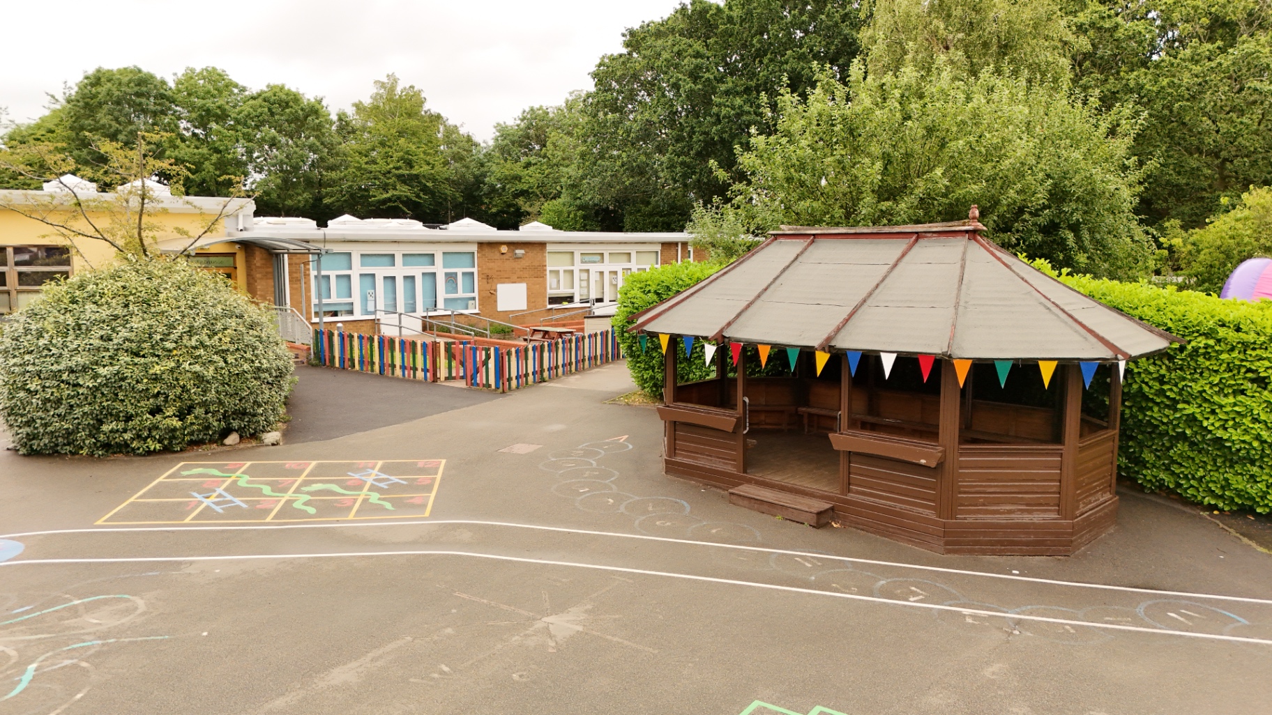 Nursery entrance with a wooden gazebo and bunting in the playground