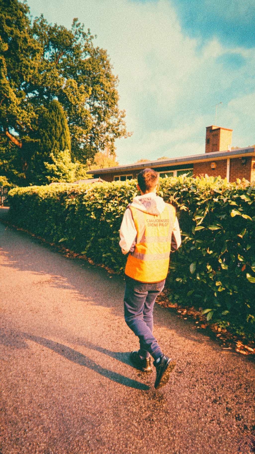 CAA-licensed drone pilot walking along a path beside a hedge