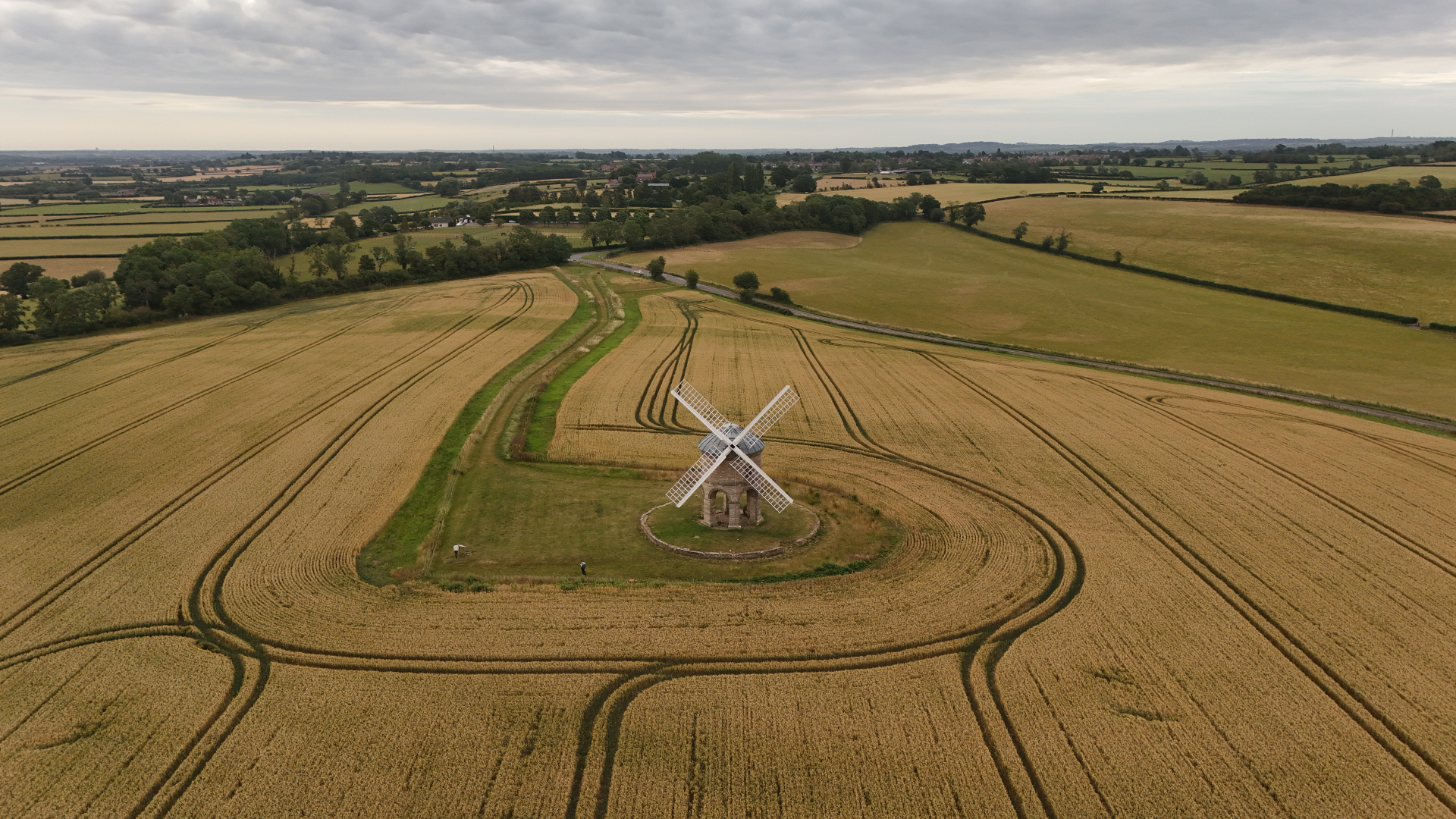 Wide aerial of Chesterton Windmill set within patchwork wheat fields