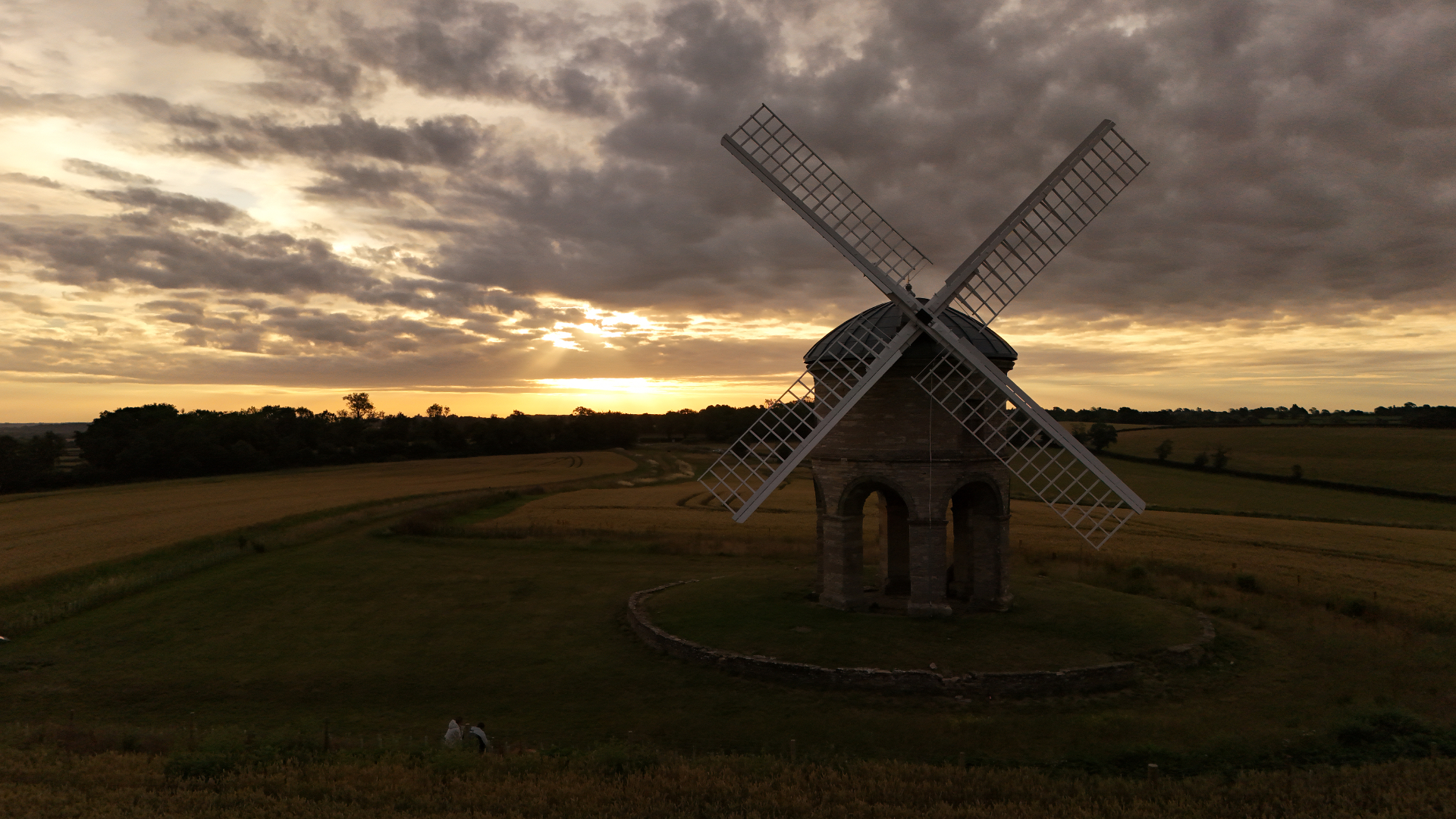 Cinematic aerial of Chesterton Windmill silhouetted at sunset