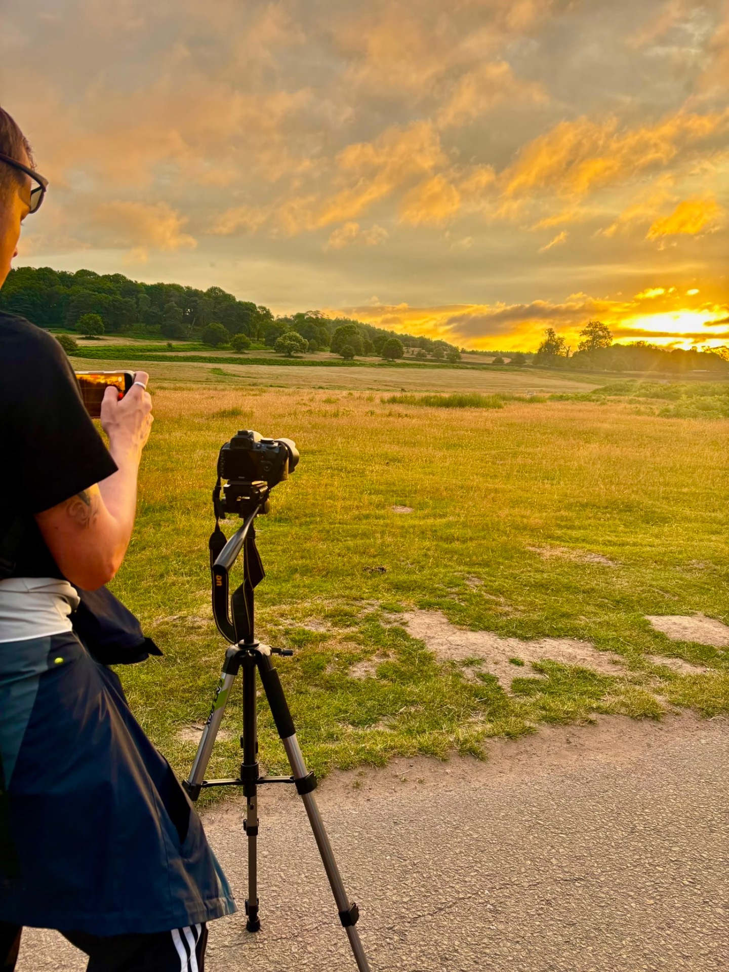 Pilot framing a golden-hour landscape on a tripod-mounted camera